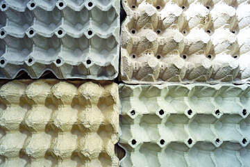 Background with empty cells: a fragment of four trays for storing eggs of different colors. Used...