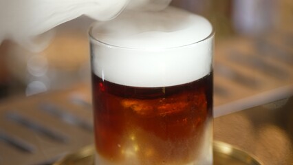 Focusing serving mist smoky classical in Old fashioned of whiskey cocktail presentation on bokeh background recommending special welcome tasty creative advertisement drink at beverage bar. Vinosity.