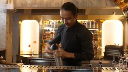 Closeup Asian hand bartender shaking mixed cocktail at luxurious counter preparation for making special drink menu looking at camera fronted view. Special refresh drink showcasing nightlife. Vinosity.
