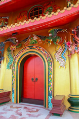 Red door on a yellow building decorated with dragon designs