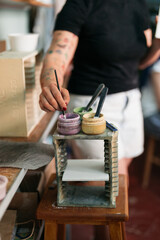 woman painting tile in a workshop

