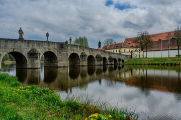 Fototapeta premium A stone bridge with statues crossing a lake