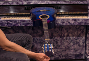 man hand adjusting acoustic guitar