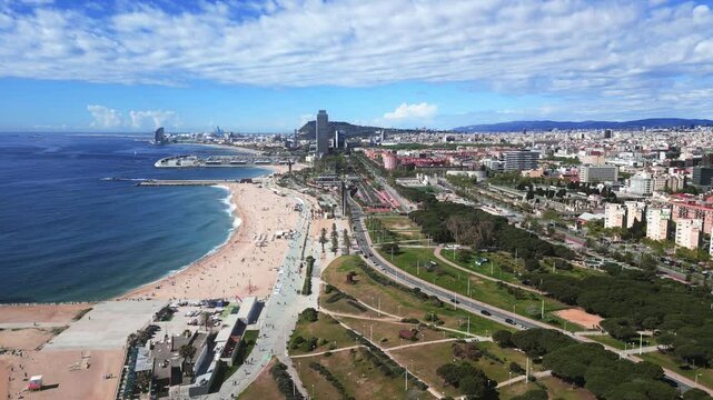 Slow aerial stock footage over the Barcelona (Spain) esplanade, showcasing the city meeting the beach
along a walking track lined with palm trees. Shot with a DJI Mini 3 Pro in 4k at 60 fp