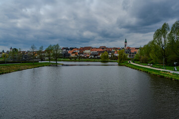 View of a city with a church behind a lake in a park