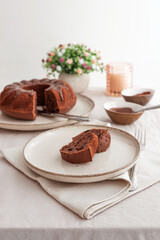 Chocolate cake with chocolate icing on white wooden table. Front view