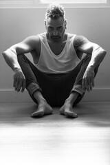 Obraz premium man on the floor of his house sitting in a tough attitude