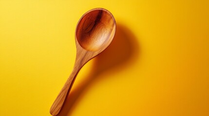 Wooden Spoon on Vibrant Yellow Background