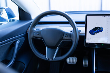 Close up of steering wheel of a new electric vehicle, interior cockpit, electric buttons, digital...