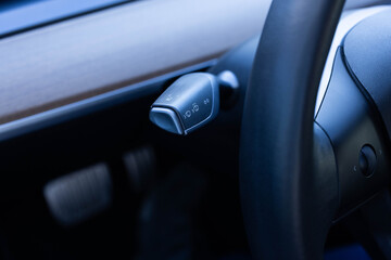 Obraz premium Detail of turning signal, headlights controller in modern car. Multifunction Headlight Console Control Switch knob of electric car. Handle with buttons windshield wiper, turn signal, and washer in car