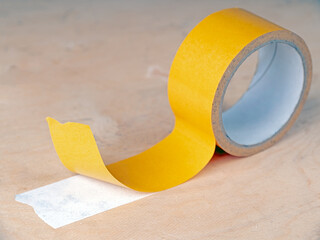 Double-sided tape stuck to wooden surface.