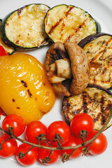 Grilled vegetables, barbecue. Fried eggplants, tomatoes, peppers and mushrooms on a white plate