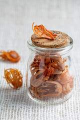 Indian spice mace or javitri in a jar on white burlap. Ayurvedic spices. Healthy flavoring.