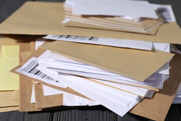 Different paper envelopes on grey wooden table, closeup. Post office