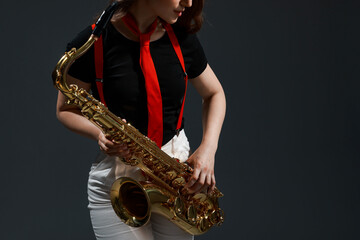 Obraz premium Professional musician with saxophone on grey background, closeup. Space for text
