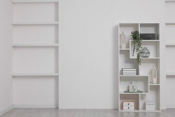 Shelving unit with decor near white wall indoors