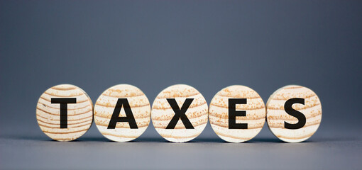 Taxes symbol. Concept word Taxes on beautiful wooden circles. Beautiful grey table grey background. Business lifestyle taxes concept. Copy space.