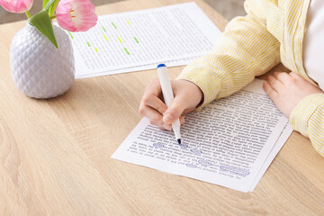 Obraz premium Woman circling important information with marker at wooden desk indoors, closeup