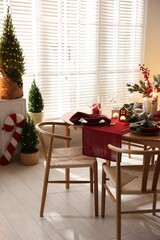 Christmas table setting with stylish dishware and festive decor indoors