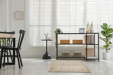 Console table with different decor and chairs indoors. Interior design