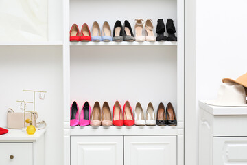 Shoe storage. Shelving unit with different high heeled shoes and accessories indoors