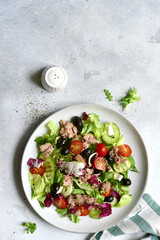 Fresh vegetable salad with tuna on a plate . Top view with copy space.