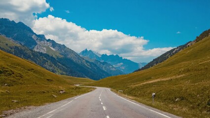 Fototapeta premium A mountain road winding its way through a picturesque valley with towering peaks in the background.