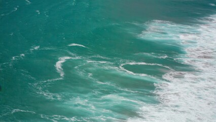 Ocean waves crashing at the shore of a beautiful beach.
