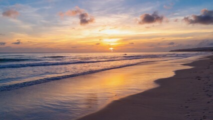 A tranquil sunset scene at the beach with reflective water and clouds in the sky.