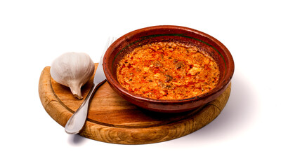 A steaming Tavë Dheu served in a rustic clay pot, paired with fresh garlic on a wooden board, celebrating hearty Albanian tradition