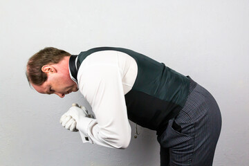 Butler or Loyal Servant in Formal Attire and White Gloves Bowing in Respectful Greeting. Professional Hospitality and Courtesy.