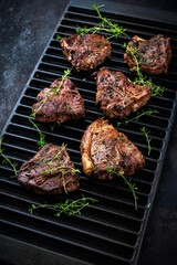 Authentic barbecued T-Bone lamb steak with thyme served as close-up on a rustic grillage