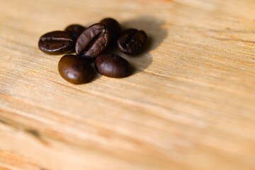 Coffee beans arranged on a piece of raw, freshly split wood.