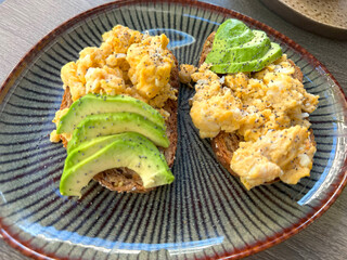 Breakfast with avocado toast, scrambled eggs, fruit salad, healthy meal, fresh ingredients, brunch time, wholesome plate