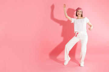 Happy woman dancing on pink background. Space for text