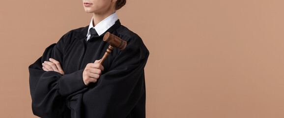 Judge with mallet on light brown background, closeup. Space for text