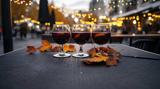 Three Glasses Of Mulled Wine On Outdoor Table With Fall Leaves