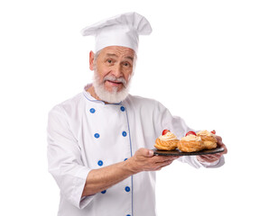 Professional pastry chef with delicious profiteroles on white background