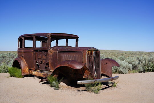 A vintage car sits on Route 66 at Petrified Forest National Park in Arizona, USA