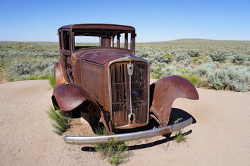 A vintage car sits on Route 66 at Petrified Forest National Park in Arizona, USA