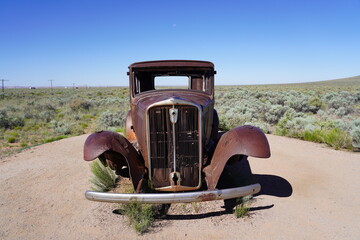 A vintage car sits on Route 66 at Petrified Forest National Park in Arizona, USA
