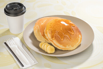 Breakfast of banana hotcakes, accompanied by coffee.