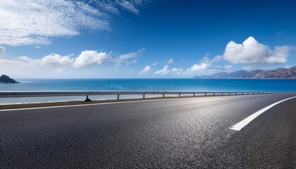 Fototapeta premium asphalt road and coastline with sky clouds under blue sky