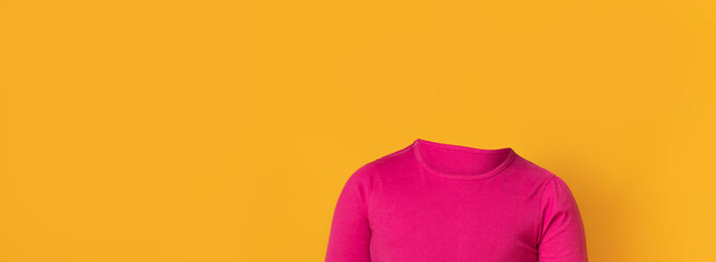 A headless figure in a vibrant pink shirt poses against a solid yellow backdrop. The unique...