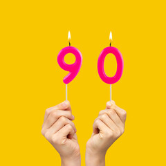 Birthday number 90 - Hands holding fuchsia colored candles