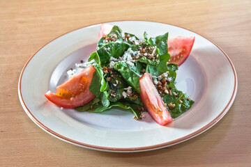 Spinach salad with tomato, walnut pieces, cheese and balsamic dressing, vegetarian food
