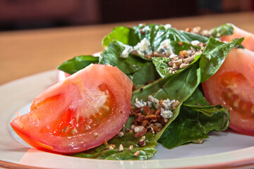 Spinach salad with tomato, walnut pieces, cheese and balsamic dressing, vegetarian food