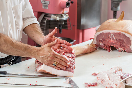butcher cutting meat on wooden board