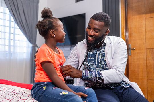 Pediatric care, a African doctor monitors the heartbeat of a young African girl with a stethoscope, ensuring compassionate and thorough healthcare for children.