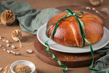 Portuguese traditional Easter cake Folar without eggs on easter table with a green ribbon and small...